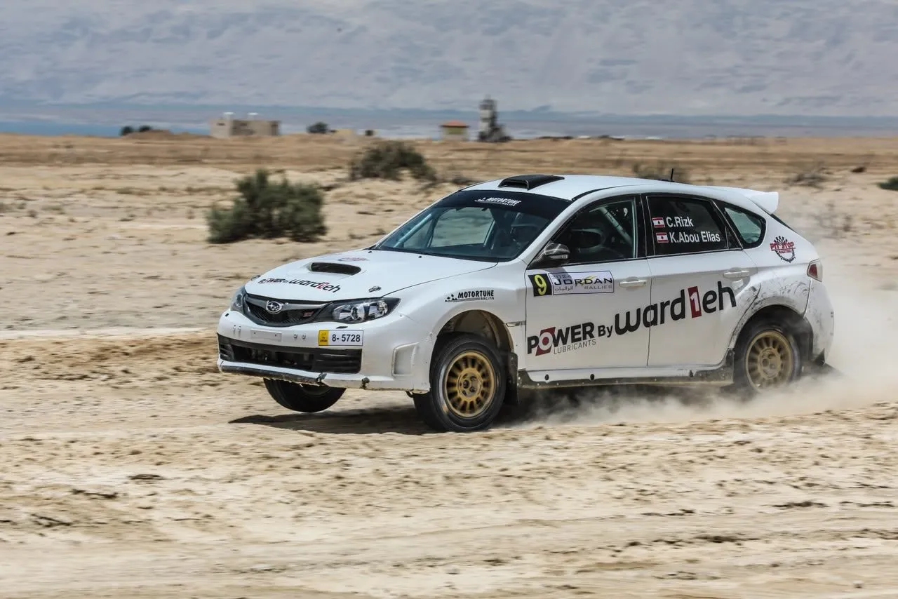 Carl Rizk's number 9 Subaru sliding through a gravel corner