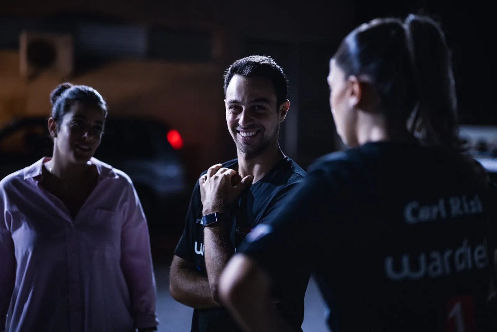 Carl Rizk smiling with the team at night